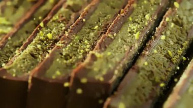 Ezilmiş Pistachios 'un Süper Yavaş Hareketi Dubai Çikolata Parçalarının üzerine düşüyor. Yüksek Hız Sinema Kamerası, 4K.