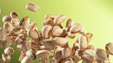 Süper Yavaş Çekim Taze Fıstıklı Fındık Yeşil Arkaplanda Uçuyor. Yüksek Hız Sinema Kamerası, 4K.