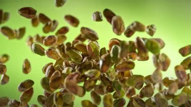 Taze Soyulmuş Pistachio Fındıklarının Süper Yavaş Çekimi. Yeşil Arka planda Uçuyor. Yüksek Hız Sinema Kamerası, 4K.