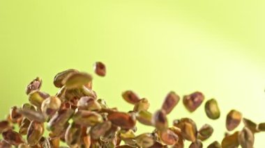 Taze Soyulmuş Pistachio Fındıklarının Süper Yavaş Çekimi. Yeşil Arka planda Uçuyor. Yüksek Hız Sinema Kamerası, 4K.