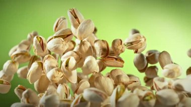 Süper Yavaş Çekim Taze Fıstıklı Fındık Yeşil Arkaplanda Uçuyor. Yüksek Hız Sinema Kamerası, 4K.