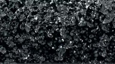 Uçan Su Damlalarının Süper Yavaş Çekimi Kara Arkaplanda izole edildi, 1000 fps. Yüksek Hız Sinema Kamerası, 4K.