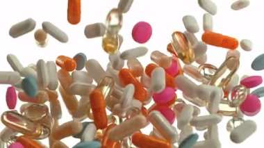 Beyaz Arkaplan 'a düşen çeşitli hapların Süper Yavaş Hareketi. Yüksek Hız Sinema Kamerası, 4K.