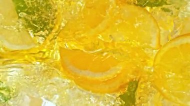 Süper Yavaş Çekim Limonata Taze Limon Dilimleri, Buz ve Yeşil Yapraklar 'ın üstüne 1000fps. Yüksek Hız Sinema Kamerası, 4K.