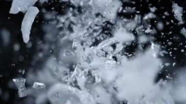 Buz Parçalarının Süper Yavaş Çekimi Kara Arkaplan 'da Kara Arkaplan' da kameraya doğru uçuyor. 4K 'da Yüksek Hız Sinema Kamerası ile çekildi..