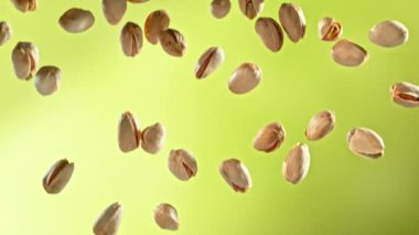 Yeşil Gradyan Arkaplan 'da Düşen Fıstık' ın Süper Yavaş Çekimi. Yüksek Hız Sinema Kamerası, 4K.