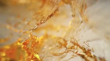 Uçan Altın Sıvı 'nın Süper Yavaş Çekimi Işık Arkaplan' daki Kameraya doğru 1000fps hızla sıçradı. Yüksek Hız Sinema Kamerası, 4K.