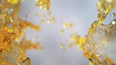 Işık Arkaplanı 'ndaki Altın Sıvı Akımı' nın Süper Yavaş Çekimi. Yüksek Hız Sinema Kamerası, 4K.