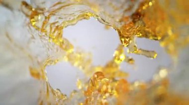 Işık Arkaplanındaki Altın Sıvı Akım Süper Yavaş Film Çekimi. Yüksek Hız Sinema Kamerası, 4K.