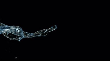 Uçan bir suyun yüksek hızda görüntüsü yavaş çekimde, siyah arka planda izole edilmiş. Birleşiklik için ideal, reklamlar, kozmetik ürünleri ve içecek görselleri. 4K çözünürlükte 1000Fps 'de çekilmiştir..