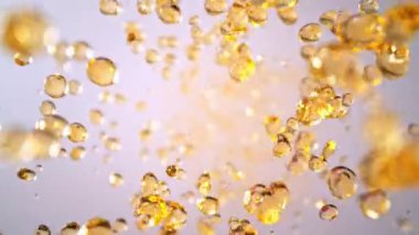 Uçan Altın Sıvı Düşürmenin Süper Yavaş Çekimi Işık Arkaplan 'daki Kameraya doğru 1000fps' de. Yüksek Hız Sinema Kamerası, 4K.