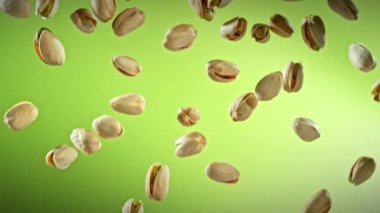 Yeşil Gradyan Arkaplan 'da Düşen Fıstık' ın Süper Yavaş Çekimi. Yüksek Hız Sinema Kamerası, 4K.