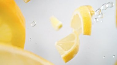 Süper Yavaş Çekim Limon Dilimleri ve Su Damlaları Kamera Merceğinin etrafında 1000 Fps hızla uçuyor. Yüksek Hız Sinema Kamerası, 4k.