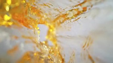 Işık Arkaplanı 'ndaki Altın Sıvı Akımı' nın Süper Yavaş Çekimi. Yüksek Hız Sinema Kamerası, 4K.