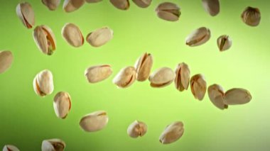 Yeşil Gradyan Arkaplan 'da Düşen Fıstık' ın Süper Yavaş Çekimi. Yüksek Hız Sinema Kamerası, 4K.