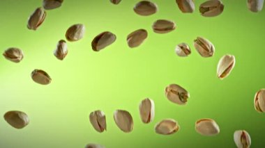 Yeşil Gradyan Arkaplan 'da Düşen Fıstık' ın Süper Yavaş Çekimi. Yüksek Hız Sinema Kamerası, 4K.