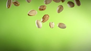 Yeşil Gradyan Arkaplan 'da Düşen Fıstık' ın Süper Yavaş Çekimi. Yüksek Hız Sinema Kamerası, 4K.