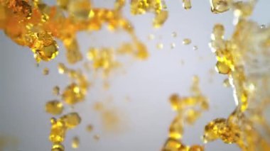 Işık Arkaplanı 'ndaki Altın Sıvı Akımı' nın Süper Yavaş Çekimi. Yüksek Hız Sinema Kamerası, 4K.