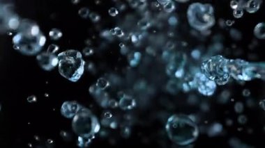 Kara Arkaplanda Uçan Su Damlalarının Süper Yavaş Çekimi. Yüksek Hız Sinema Kamerası, 4K.