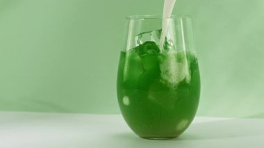 Süper Yavaş Çekim, Yeşil Kibrit İçeceğinin içine krema dökme sahnesi. Kamera Hareketi 'yle birlikte. Yüksek Hız Sinema Kamerası, 4K.