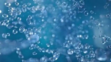 Mavi Arkaplanda Uçan Su Damlalarının Süper Yavaş Çekimi. Yüksek Hız Sinema Kamerası, 4K.