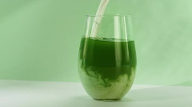 Süper Yavaş Çekim, Yeşil Kibrit İçeceğinin içine krema dökme sahnesi. Kamera Hareketi 'yle birlikte. Yüksek Hız Sinema Kamerası, 4K.