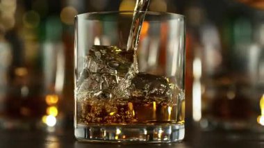 Super Slow Motion Shot of Pouring Whiskey into Glass with Ice Cubes at 1000fps with Camera Movement. Filmed with High Speed Cinema Camera at 4K.