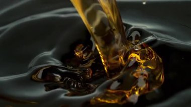 Süper Yavaş Çekim Çekimi, Siyah Arkaplan 'a 1000fps' de Altın Sıvı Dökme ve Sıçratma. Yüksek Hız Sinema Kamerası, 4K.