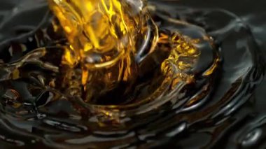 Süper Yavaş Çekim Çekimi, Siyah Arkaplan 'a 1000fps' de Altın Sıvı Dökme ve Sıçratma. Yüksek Hız Sinema Kamerası, 4K.