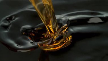 Süper Yavaş Çekim Çekimi, Siyah Arkaplan 'a 1000fps' de Altın Sıvı Dökme ve Sıçratma. Yüksek Hız Sinema Kamerası, 4K.