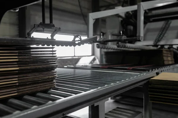 stock image Close-up on blanks for recycled paper boxes on a conveyor machine in a recycling plant.