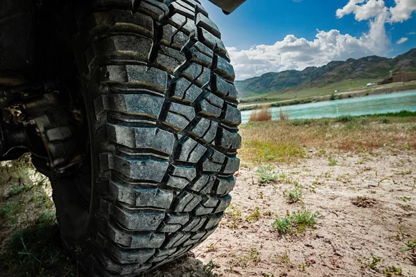 4x4 car mud tire on off road close-up. 4WD SUV car traveling on wild nature.