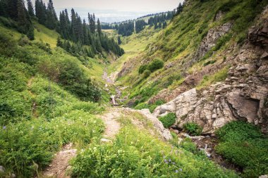 Famous tourist hiking route in the mountains of Almaty - Kimasar Gorge, View towards the city of Almaty.