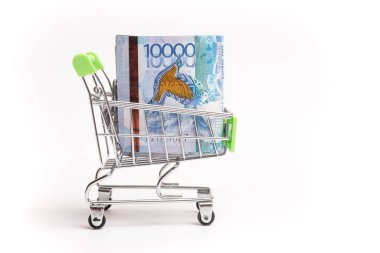 10000 Kazakhstani tenge in a shopping cart isolated on white background.