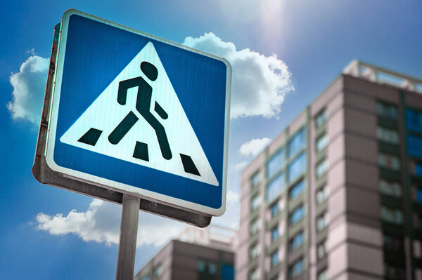 Крупный план на дорожном знаке для пешеходного перехода в жилом районе.