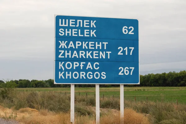 stock image Road sign with directions to Chilik, Zharkent and Khorgos on the concrete road Khorgos tract in Kazakhstan. Almaty, Kazakhstan - August 21, 2022.