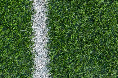 Futbol sahasının yeşil çimlerinde beyaz çizgili izler var..