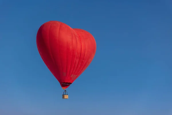 stock image Hot air balloon in the shape of a heart in the blue sky. Honeymoon concept for newlyweds.