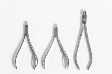 Beyaz arka planda 3 farklı manikür cımbızı ya da tırnak makası.
