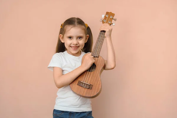 Beyaz Tebessüm Eden Mutlu Ilkokul Kızı Gitar Çalmayı Öğreniyor — Stok fotoğraf