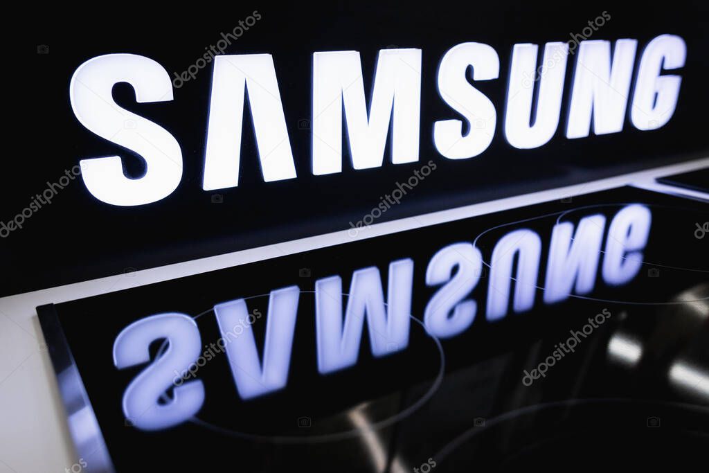 The SAMSUNG logo on the stand is reflected in the electric cooker in the store. Almaty, Kazakhstan - April 15, 2023