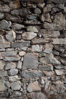 Beton harca yapıştırılmış doğal taşların dikey grunge arka planı.
