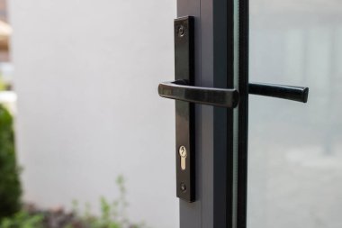 Arka bahçeye erişimi olan cam kapıya kilitlenmiş kapı kolu..