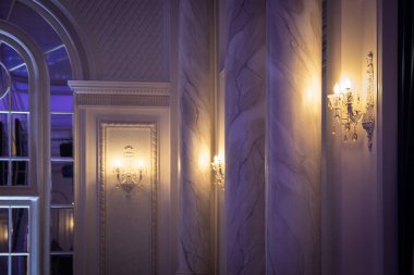 Salonun iç kısmının bir kısmı klasik tarzda ve duvarlarında parlak bir lamba var..