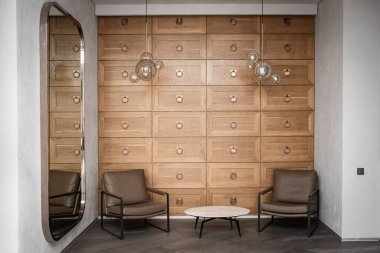 Modern bekleme salonunun içinde küçük bir otel sehpası ve iki koltuk, yurt lobisi iç mekanı..