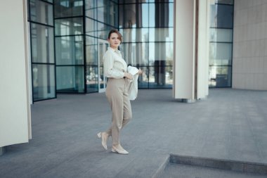 Modern iş binasının önünde başarılı bir iş kadınının portresi.