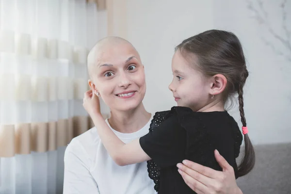 Young smiling woman with oncology is positive about recovery spending time with her daughter.