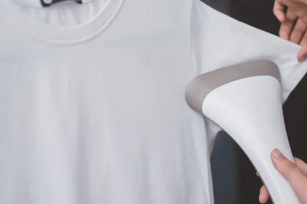 Zbliżenie Parowiec Kobiecej Dłoni Parujący Biały Shirt Przestrzeń Kopiowania — Zdjęcie stockowe