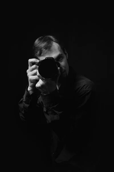 暗闇の中でカメラを持ったプロの写真家の黒と白の肖像画 — ストック写真