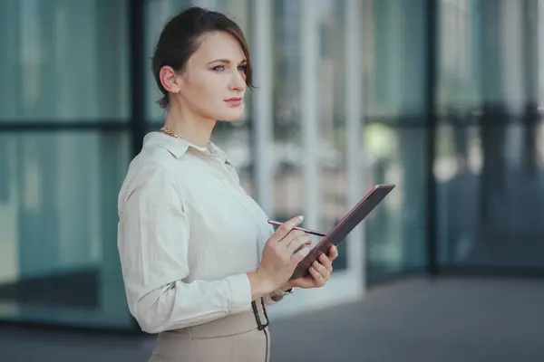 Business woman with tablet in her hands. The concept of conducting and controlling business processes remotely.